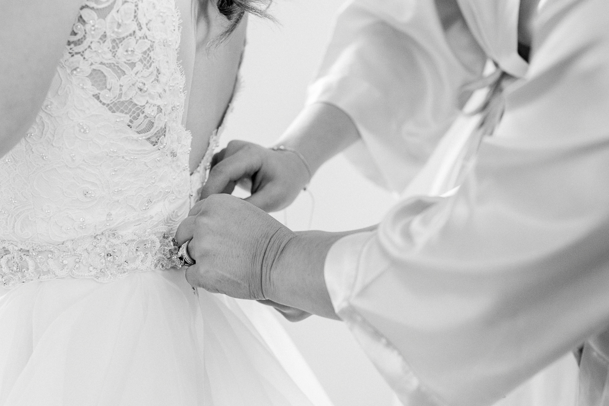 Mom buttoning up bride's dress | Orlando Wedding Photographer