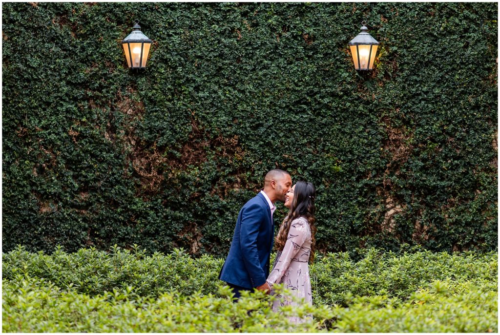 Bride and groom laughing infront of greenery wall