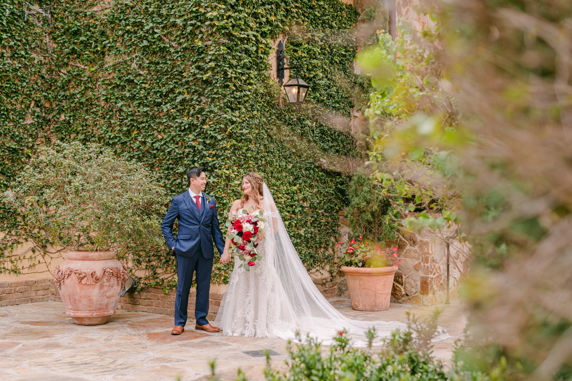 Bride and Groom holding hands smiling at one another at Bella Collina