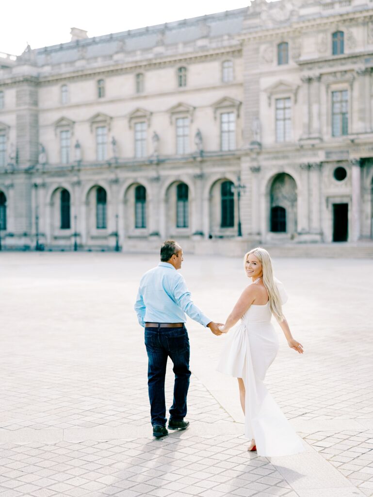 Couple running around the Louvre in Paris
