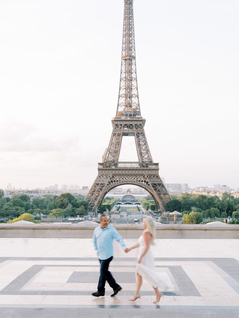 Couple running in front of the Eiffel Tower