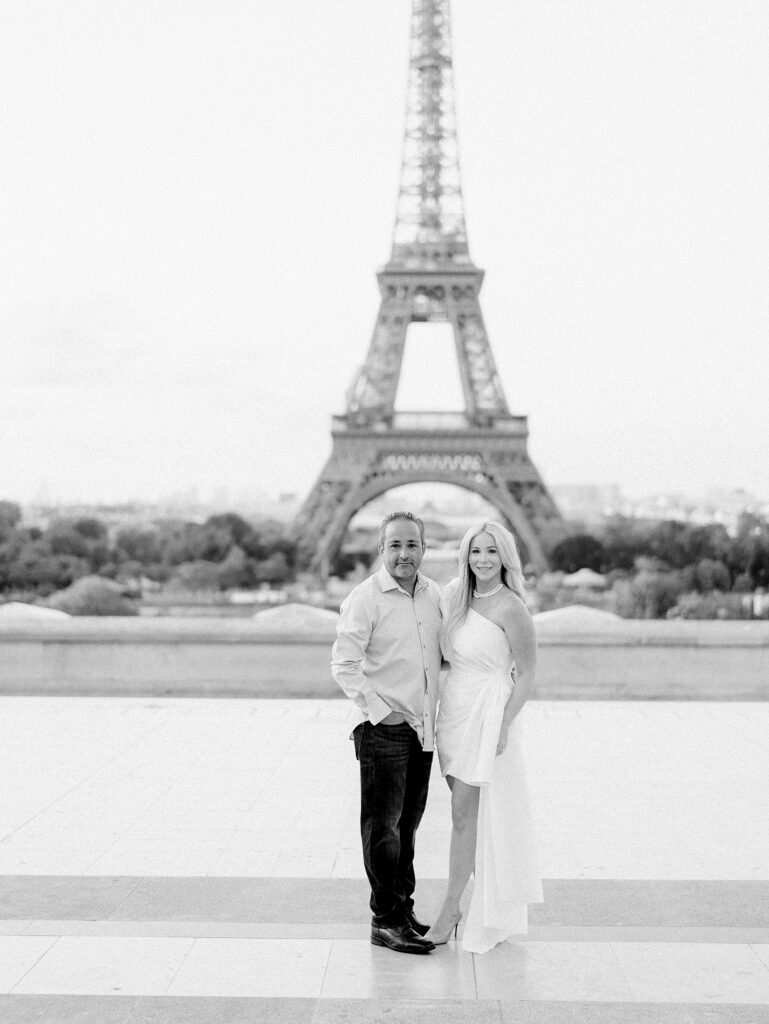 Couple smiling in front of the Eiffel Tower in Paris