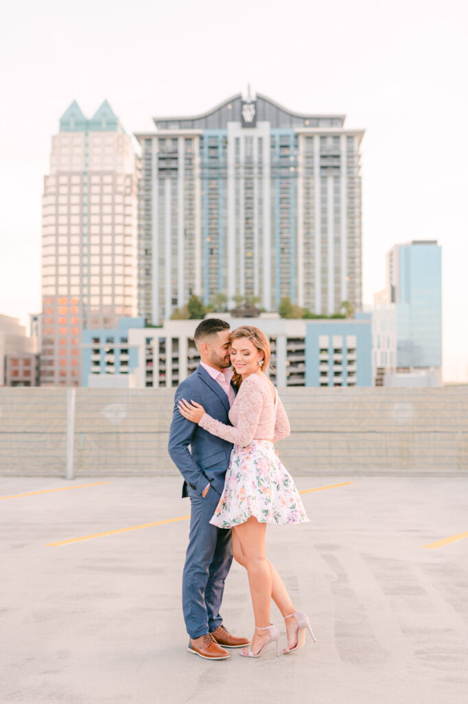 Downtown Orlando rooftop engagement portraits in front of tall buildings